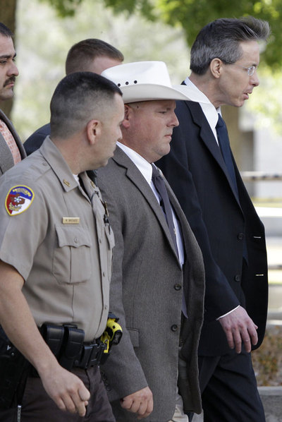 Warren Jeffs (con gafas), líder de la secta mormona, sale escoltado del juzgado de San Ángelo (Tejas) .