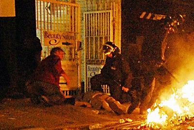 Un policía y un vecino del barrio de Ealing atienden a Richard Mannington (abajo, a la izquierda), que yace en el suelo tras recibir una paliza.