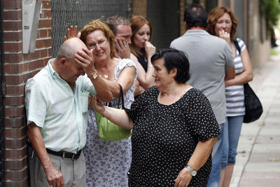El cuñado de María Isabel Martínez llora desconsolado tras la salida del cuerpo de la víctima.