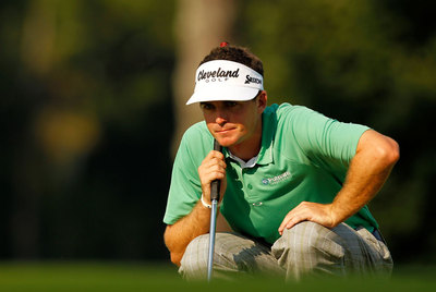 Keegan Bradley estudia la línea del  putt. 