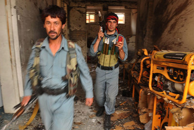 Dos soldados afganos inspeccionan el lugar atacado por los talibanes en la sede del gobernador de Parwan, al noroeste de Kabul.