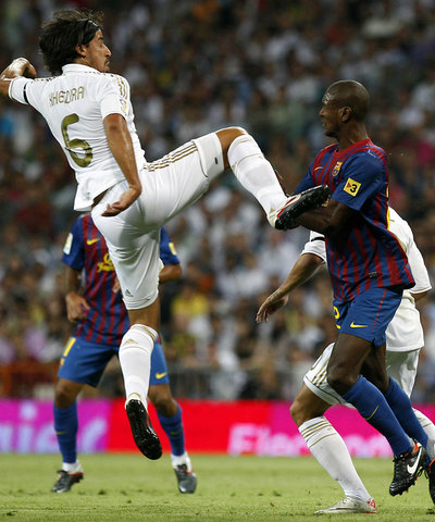 Khedira levanta el pie ante Abidal.