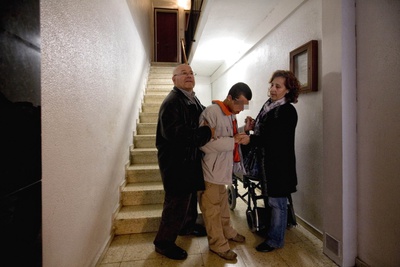 Los padres de Adrián Yepes le ayudan a bajar las escaleras en su casa de Cornellà.