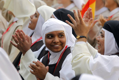 Varias monjas de distintas nacionalidades aplauden durante el encuentro que mantuvieron ayer con el Papa y el secretario de Estado del Vaticano, Tarcisio Bertone, en el Patio de Reyes del Monasterio de El Escorial (Madrid).