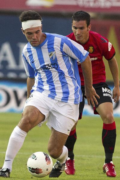 Toulalan controla el balón presionado por Alfaro.