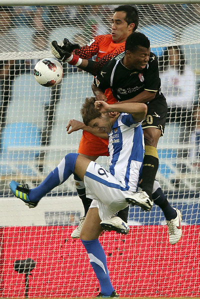 Bravo, Uche e Iñigo Martínez chocan en el área.