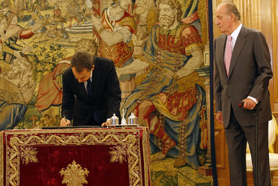 Zapatero firma la reforma en presencia del Rey.