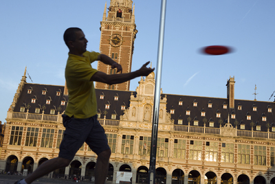 Un hombre juega al  frisbee  ante la Biblioteca de la Universidad de Lovaina