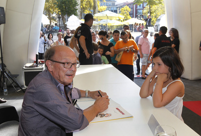 Una niña aguarda a que Francisco Ibáñez le firme un tebeo de Rompetechos.