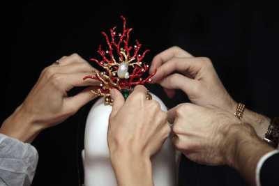 El equipo coloca un tocado coral del diseñador.