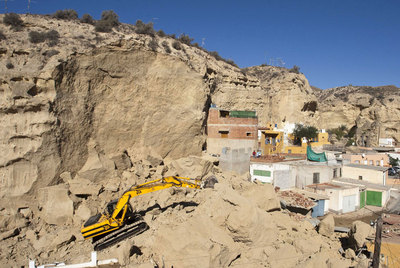 Una excavadora retira piedras y tierra en la zona del derrumbe en Cuevas de Almanzora.