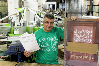 Isidro Álvarez posa con una de sus camisetas de la  marea verde  en su taller de Vallecas.