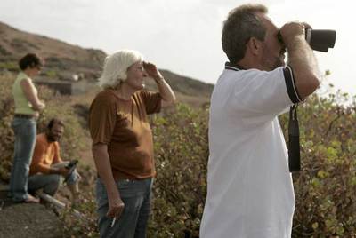 Lugareños y curiosos tratan de ver desde las zonas altas de La Restinga, en El Hierro, la mancha de la erupción volcánica.