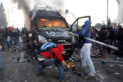 Dos manifestantes golpean un furgón policial en llamas, el pasado sábado en Roma.