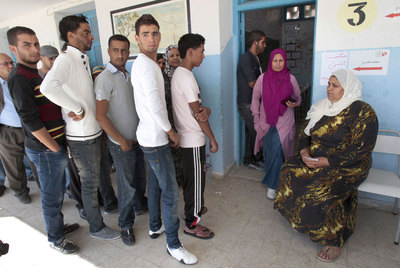 Vecinos de Sidi Bouzid, localidad en la que empezó la protesta tunecina, aguardan cola para votar en un colegio electoral.
