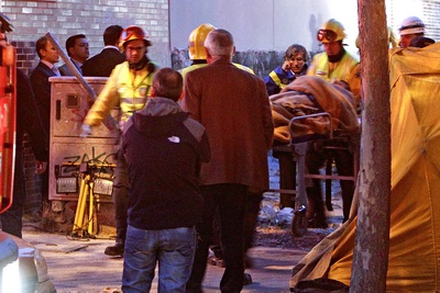 Sanitarios del Samur sacan en camilla al herido tras el accidente en la calle de Iquitos.