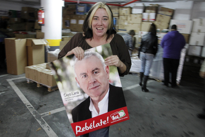 Una dirigente de IU muestra un cartel electoral de Cayo Lara, ayer en la sede de la formación.