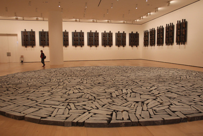En primer término  Círculo de Bilbao,  de Richard Long, una instalación hecha con trozos de pizarra que se exhibe en el Guggenheim. Al fondo, sobre la pared,  Sin título,  de Jannis Kounellis.