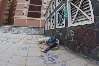 Un hombre duerme en la calle en la zona en que deambulaba Iván tras ser expulsado de un centro de menores.