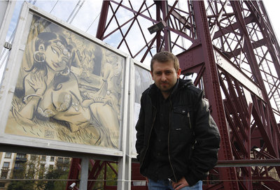 Víctor Santos ante una de las viñetas expuestas junto al Puente Colgante.