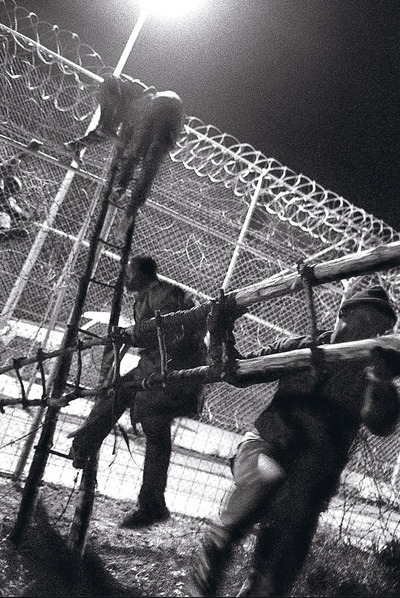 Un grupo de inmigrantes saltan la valla de la frontera de Melilla en el año 2005.
