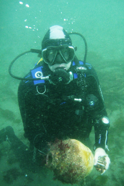 Uno de los buceadores profesionales de la campaña, con la anforeta encontrada en la ría de Ribadeo.