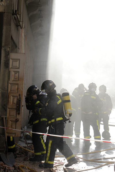 Bomberos del Ayuntamiento entran a sofocar el fuego en el subsuelo del edificio.