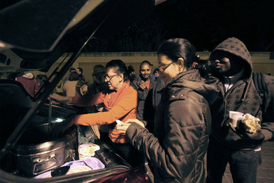 Dos de las voluntarias de Amigos de la Calle distribuyen la sopa de verduras entre varios  sin techo  de Valencia.