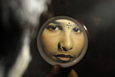 Lima, de 15 años, se prepara frente a un pequeño espejo de mano.