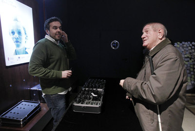 Un espectador recoge los audífonos ofrecidos por el teatro La Abadía para ayudar al público invidente a seguir la obra  En la luna. 