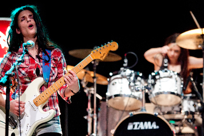 Las hermanas Biurrun -Mariana, a la guitarra, y Andrea,  a la batería-, en un momento de la actuación de su formación Wha Wha Buga Band en el concierto del pasado jueves.rnDos niños juegan en el PIN.