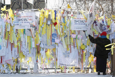 Una mujer observa los mensajes que piden la unificación de las dos Coreas en la verja que separa ambos países, en Panmunjom.rn (reuters)