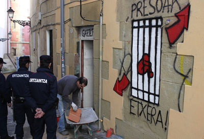 Dos  ertzainas  vigilan las labores de tapiado de la casa Uxotegi, ayer en San Sebastián.