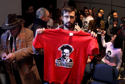 Un joven asistente al pleno luce una camiseta contra la crispación política.