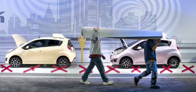 Dos operarios preparan uno de los expositores del salón automovilístico de Detroit.