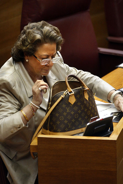 Rita Barberá busca en su bolso en las Cortes valencianas.