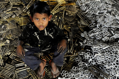 Shanta, sobre una pila de piezas producidas en la fábrica en la que trabaja.