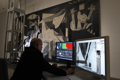 Un operario del equipo de restauración observa ayer las fotografías del  Guernica  tomadas por el robot en el Reina Sofía.