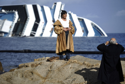 Una turista se hace fotos frente a los restos del  Costa Concordia,  semihundido frente a la isla del Giglio desde el 23 de enero.