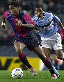 Kluivert corre con el Balón delante de Benedict McCarthy.