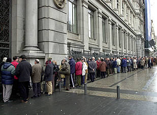 Las colas para cambiar pesetas por euros dan la vuelta al Banco de España en Madrid.