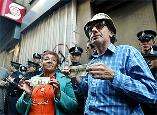 Dos víctimas del  corralito  muestran un dólar ante el banco Scotiabank Quilmes, en Buenos Aires.