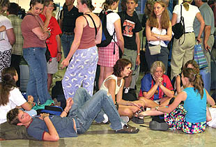 Un grupo de pasajeros espera junto al mostrador de Air France de Barajas a que salga su vuelo.