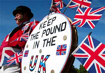 Un activista anti-euro se manifiesta frente al palacio de Westminster con el lema  Dejad la libra en el Reino Unido .