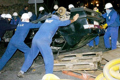 Varios trabajadores de La Naval de Sestao vuelcan un coche para montar una barricada incendiaria.