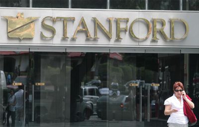 Una mujer sale de una oficina de la división venezolana de un banco de Allen Stanford, acusado de una estada de 8.000 millones de dólares, en Caracas.