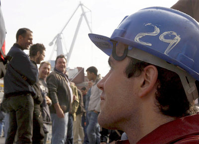 Un grupo de obreros junto a La Naval, en la ría de Bilbao.