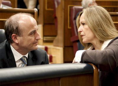 El titular de Industria, Miguel Sebastián, charla con la ministra de Sanidad, Trinidad Jiménez, en el Congreso.