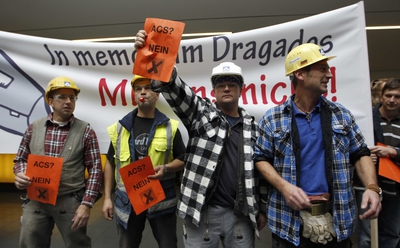 Varios trabajadores de la constructora alemana ante una pancarta que reza 