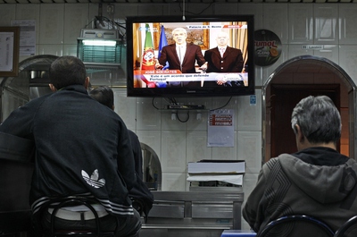 Un grupo de personas sigue desde un bar la comparecencia de Sócrates y Teixeira do Santos.
